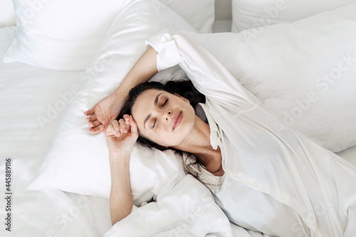 Young woman with closed eyes sleeping on bed