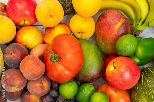 bulk fruits viewed from top view. Apples and limes  yellow peach trees  red peaches  bananas and mangoes  tomatoes and red grapes