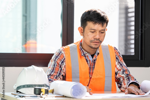 male engineer Working tools Engineer office desk with helmet at desk talbe photo