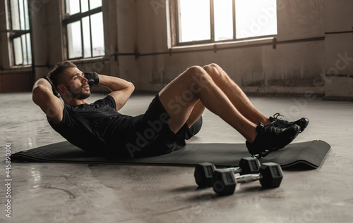 Sportsman doing abdominal crunches in gym photo