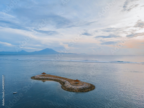 Sanur beach on the island of Bali in Indonesia. Traditional Balinese gazebos on the island. An Iconic Landmark of Sanur beach and the island of Bali. Dawn on the beach.