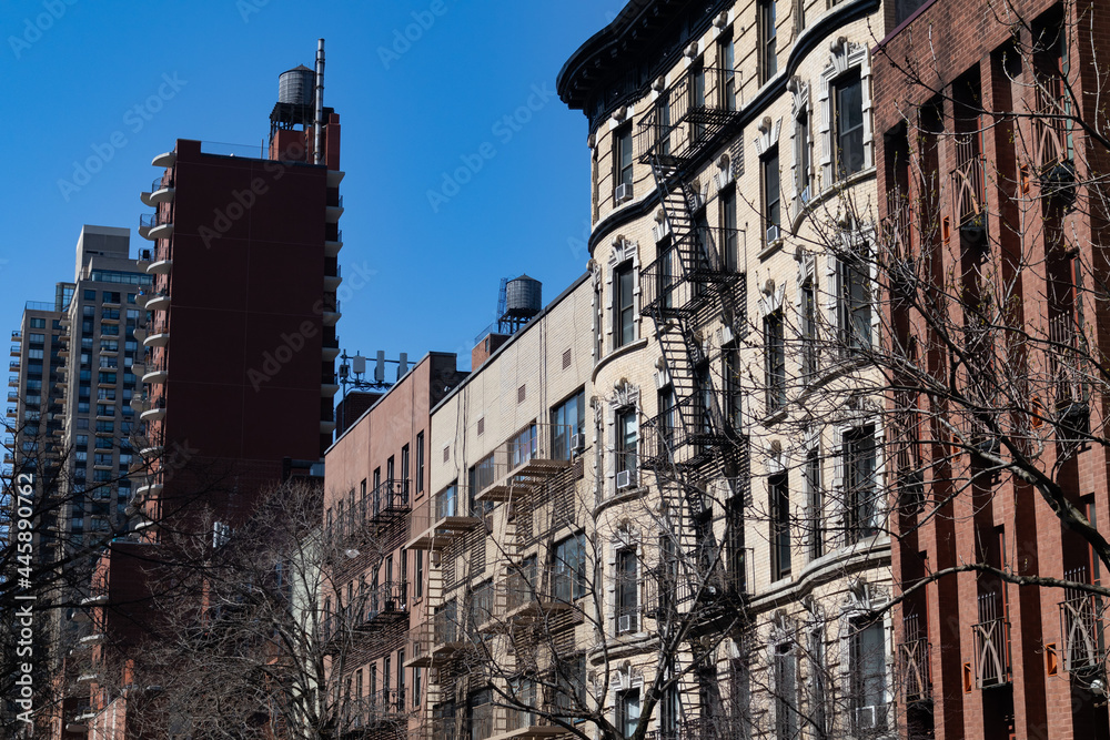 Row of Colorful Old Brick Residential Buildings on the Upper East Side of New York City with Fire Escapes