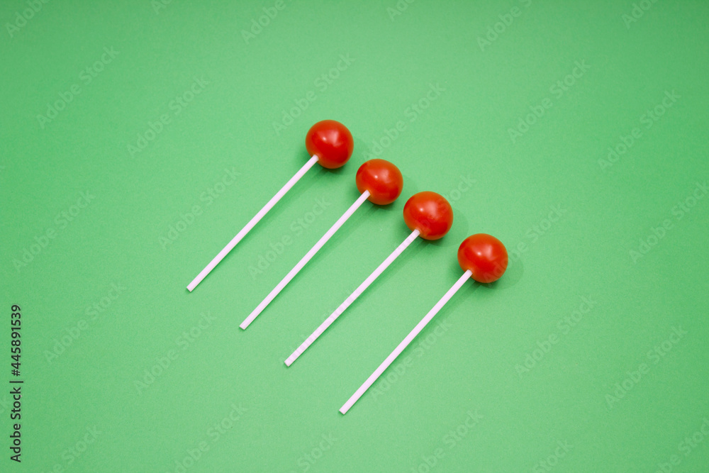Red cherry tomato as lollipop on green background. Red cherry tomato as lollipop on green background.