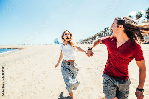 Photography Happy couple enjoying sun holidays running on the beach - Young friends having f