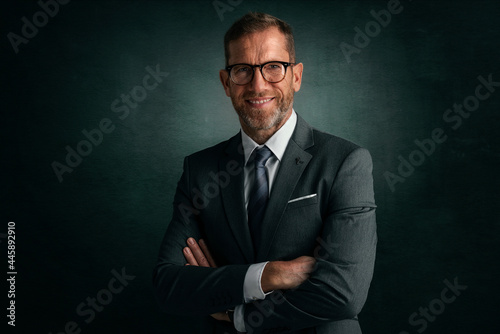 Middle aged businessman wearing suit and tie while standing a isolated background © gzorgz