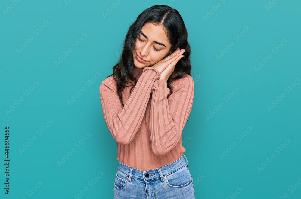 Hispanic teenager girl with dental braces wearing casual clothes sleeping tired dreaming and posing with hands together while smiling with closed eyes. Hispanic teenager girl with dental braces wearing casual clothes sleeping tired dreaming and posing with hands together while smiling with closed eyes.