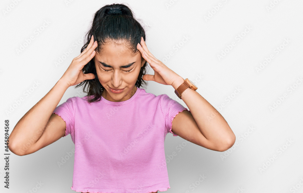 Hispanic teenager girl with dental braces wearing casual clothes suffering from headache desperate and stressed because pain and migraine. hands on head. Hispanic teenager girl with dental braces wearing casual clothes suffering from headache desperate and stressed because pain and migraine. hands on head.