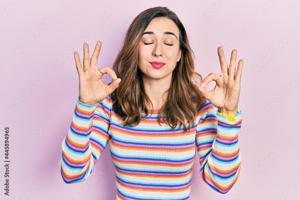 Young hispanic girl wearing casual clothes relaxed and smiling with eyes closed doing meditation gesture with fingers. yoga concept. Young hispanic girl wearing casual clothes relaxed and smiling with eyes closed doing meditation gesture with fingers. yoga concept.