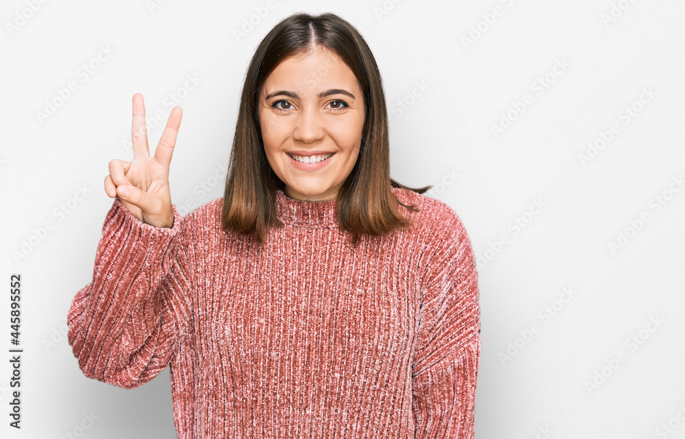 Young beautiful woman wearing casual clothes showing and pointing up with fingers number two while smiling confident and happy. Young beautiful woman wearing casual clothes showing and pointing up with fingers number two while smiling confident and happy.