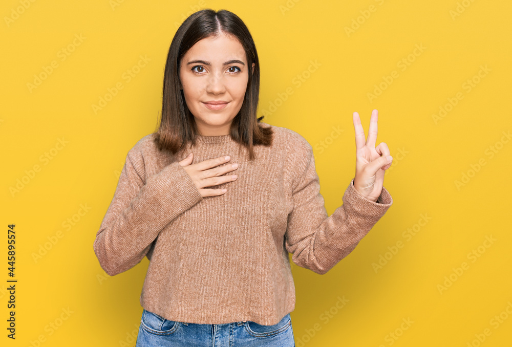 Young beautiful woman wearing casual clothes smiling swearing with hand on chest and fingers up, making a loyalty promise oath Young beautiful woman wearing casual clothes smiling swearing with hand on chest and fingers up, making a loyalty promise oath