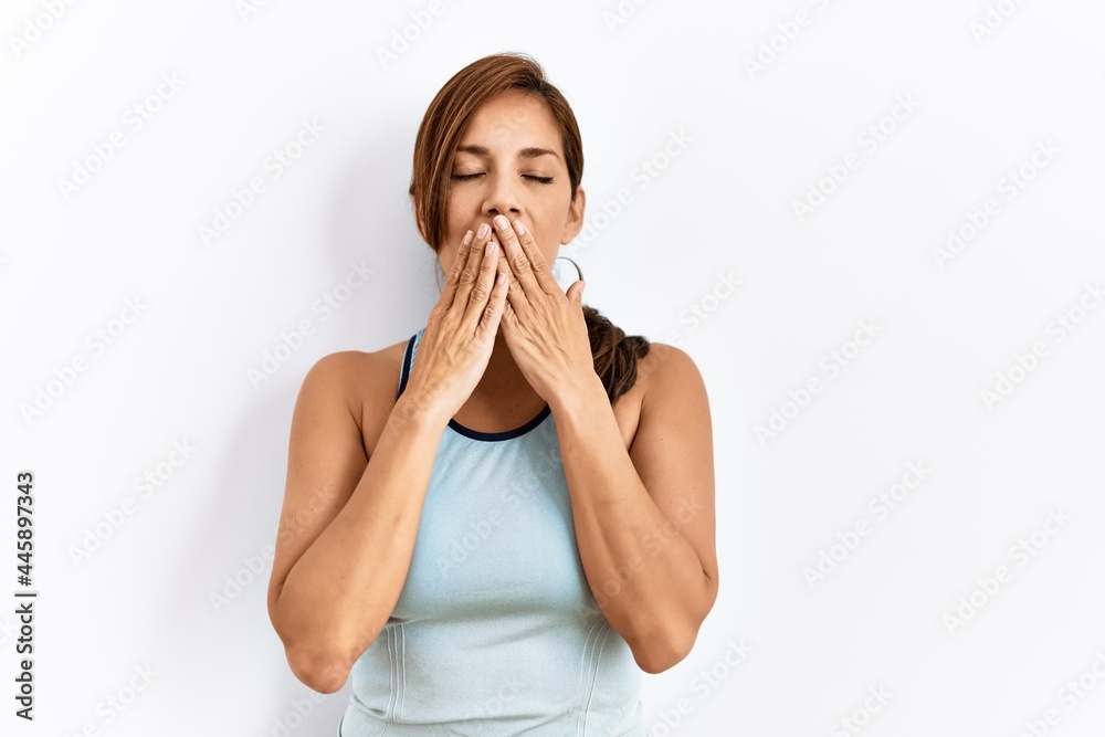 Young latin woman wearing sporty clothes over isolated background bored yawning tired covering mouth with hand. restless and sleepiness. Young latin woman wearing sporty clothes over isolated background bored yawning tired covering mouth with hand. restless and sleepiness.