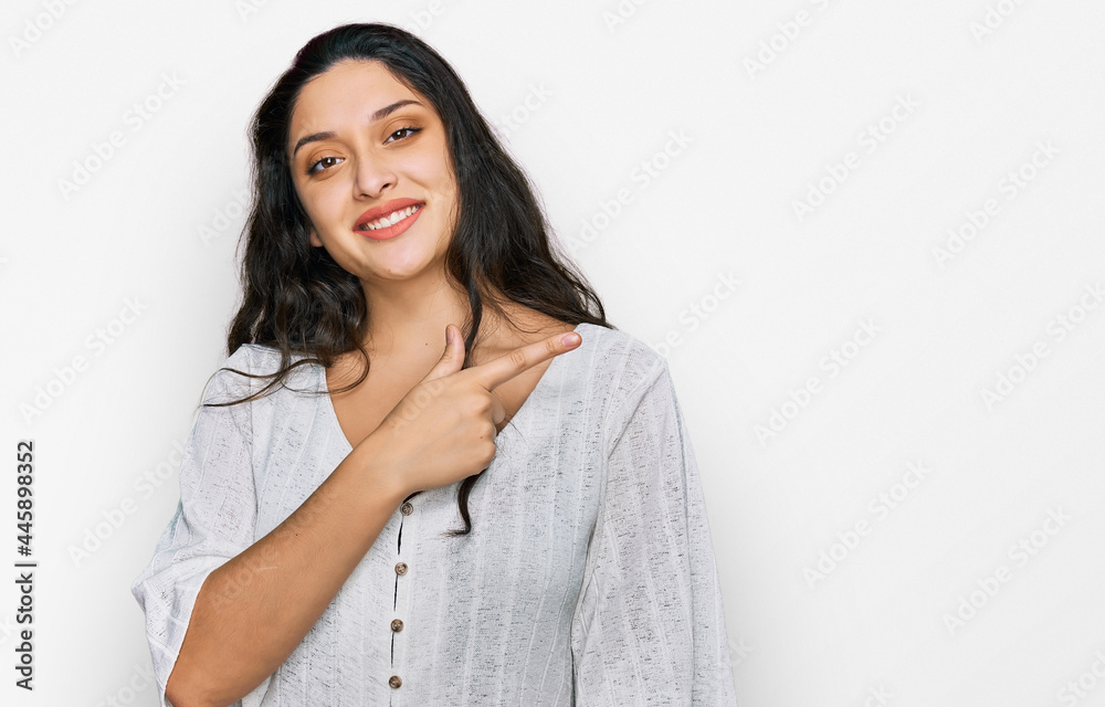 Brunette young woman wearing casual clothes cheerful with a smile of face pointing with hand and finger up to the side with happy and natural expression on face Brunette young woman wearing casual clothes cheerful with a smile of face pointing with hand and finger up to the side with happy and natural expression on face