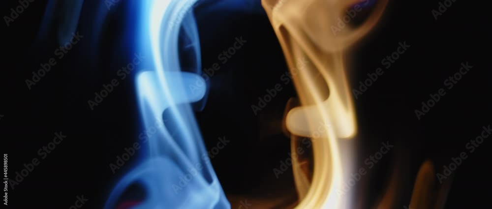 Blue and yellow incense burning flames swirling on black background in slow motion. Blue and yellow incense burning flames swirling on black background in slow motion.