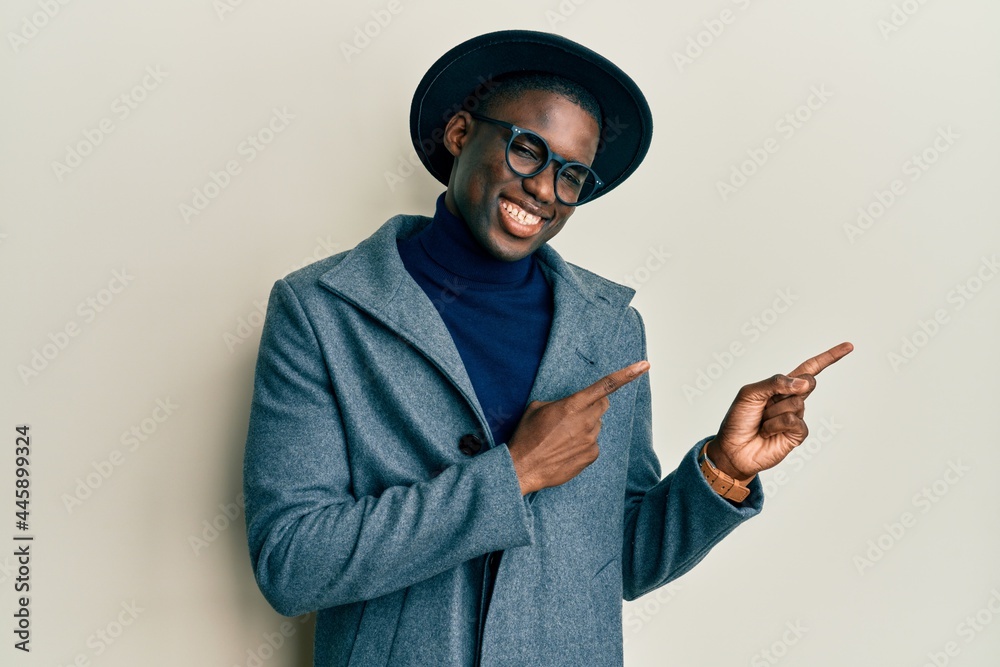 Young african american man wearing elegant style smiling and looking at the camera pointing with two hands and fingers to the side. Young african american man wearing elegant style smiling and looking at the camera pointing with two hands and fingers to the side.