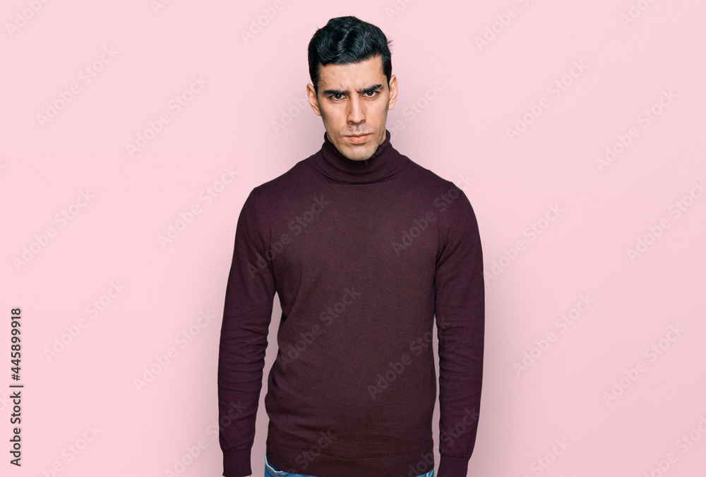 Handsome hispanic man wearing casual turtleneck sweater skeptic and nervous, frowning upset because of problem. negative person. Handsome hispanic man wearing casual turtleneck sweater skeptic and nervous, frowning upset because of problem. negative person.