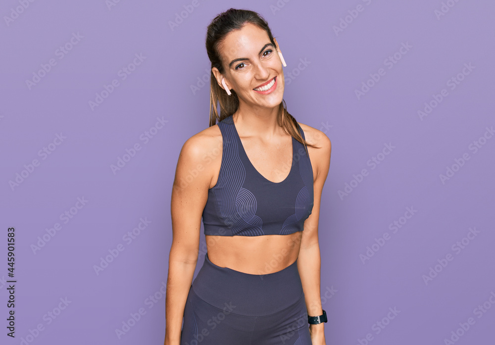 Young beautiful woman wearing sportswear looking positive and happy standing and smiling with a confident smile showing teeth Young beautiful woman wearing sportswear looking positive and happy standing and smiling with a confident smile showing teeth