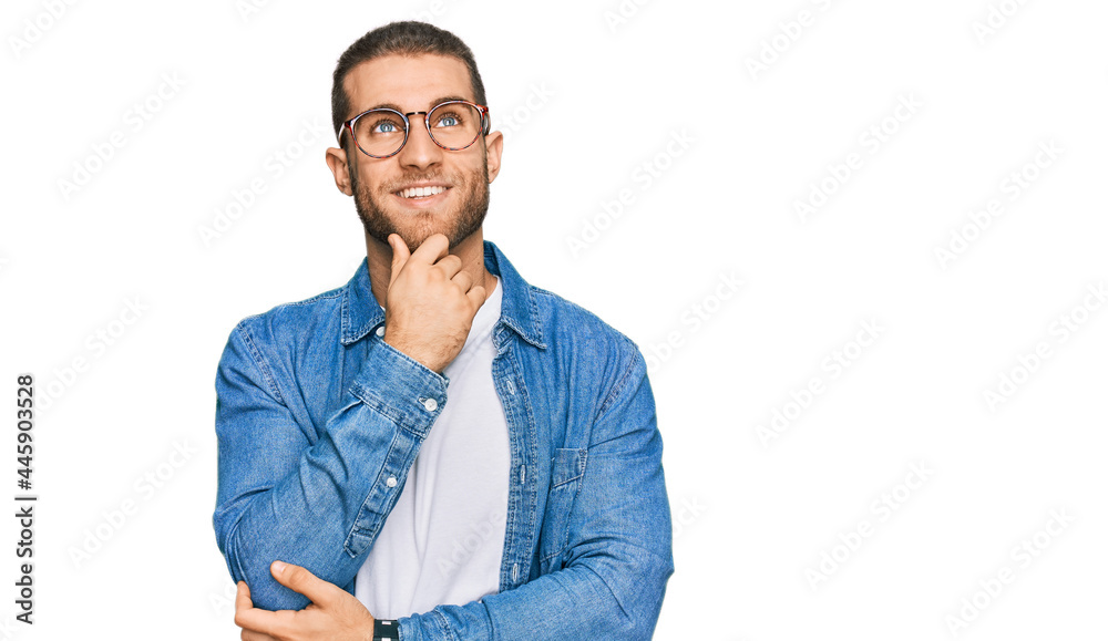 Fototapeta premium Young caucasian man wearing casual clothes with hand on chin thinking about question, pensive expression. smiling and thoughtful face. doubt concept.