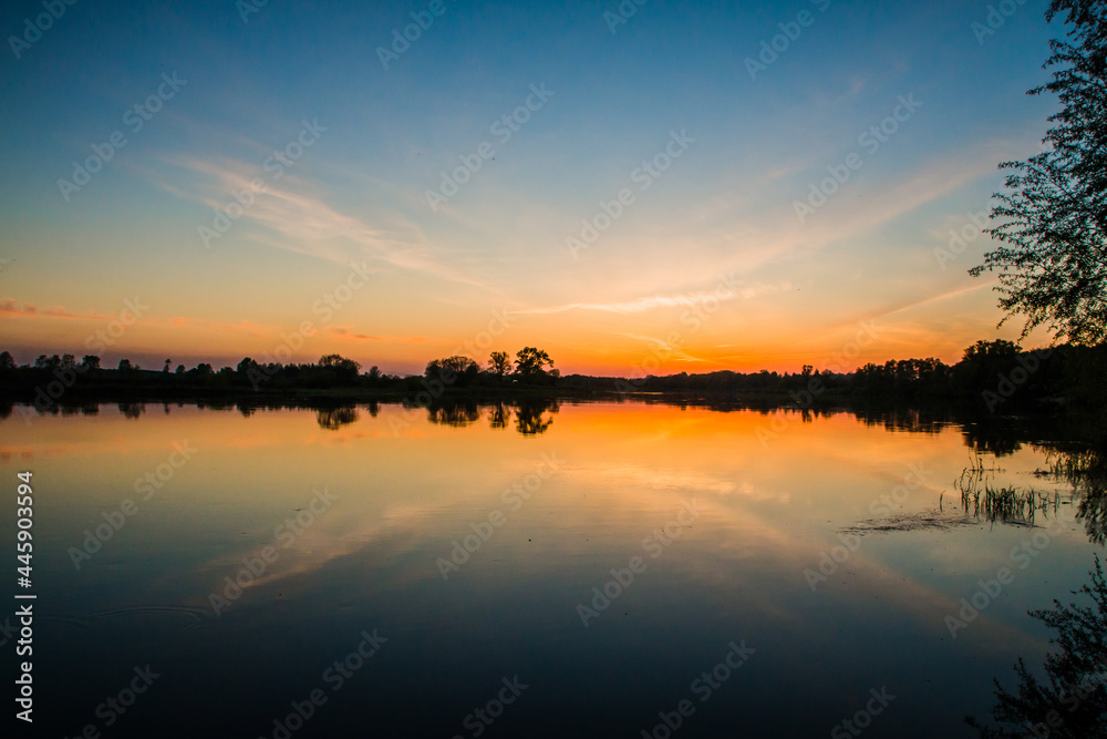 Orange sunset in the bright blue sky over the lake Orange sunset in the bright blue sky over the lake