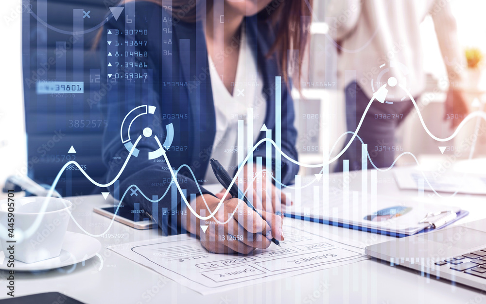 Business Woman website developer is making notes and trying to settle a new approach to deal with clients needs to boost the business and achieve exceptional financial results. blurred office.