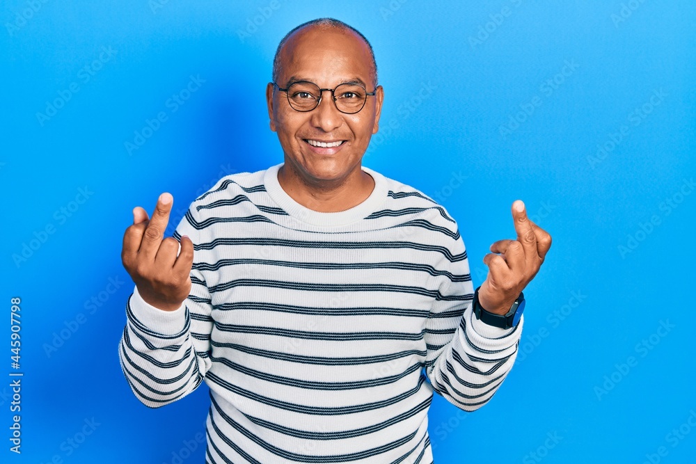 Middle age latin man wearing casual clothes and glasses showing middle finger doing fuck you bad expression, provocation and rude attitude. screaming excited Middle age latin man wearing casual clothes and glasses showing middle finger doing fuck you bad expression, provocation and rude attitude. screaming excited