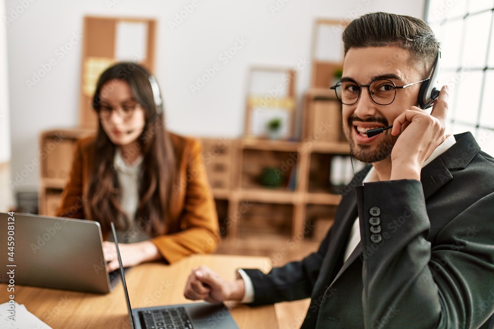Two hispanic call center agents working at the office. Two hispanic call center agents working at the office.