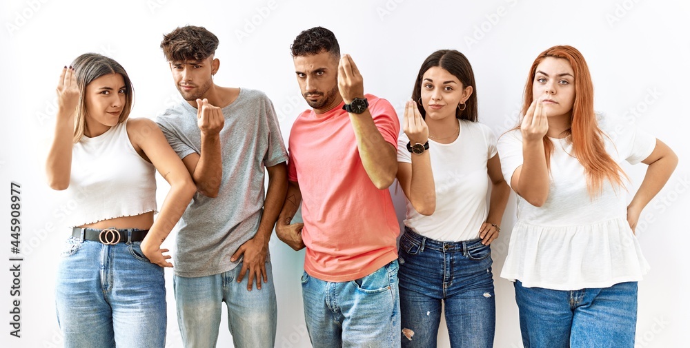 Fototapeta premium Group of young friends standing together over isolated background doing italian gesture with hand and fingers confident expression