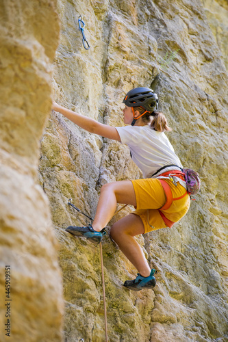 Teenage girl in a difficult rock climbing tour in the La Gola climbing area, Sarca Valley, Lake Garda mountains, Trentino Italy