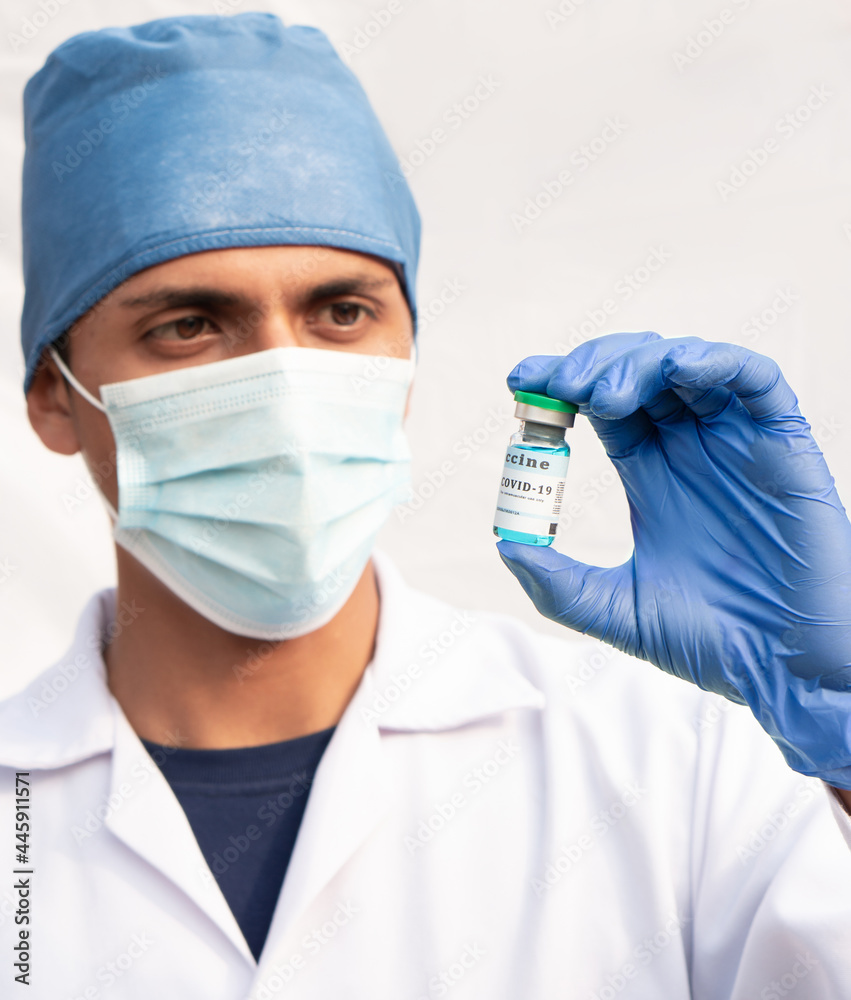 Latino nurse holding a vial containing a blue liquid, covid19 vaccine. Hispanic man on white background. Latino nurse holding a vial containing a blue liquid, covid19 vaccine. Hispanic man on white background.