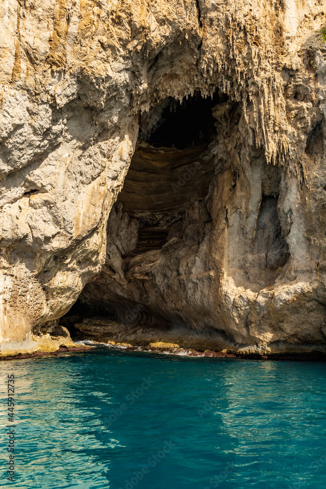 Entrance to Grotta Bianca next to azure waters next to Capri island