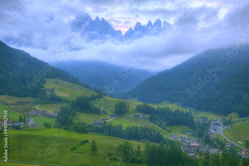 Fototapeta Naklejka Na Ścianę i Meble -  Idyllic scenery of Val di Funes in summer season with rugged peaks of Odle mountain range in background & a church in Village Santa Maddalena in the green grassy valley in Dolomiti, South Tyrol, Italy