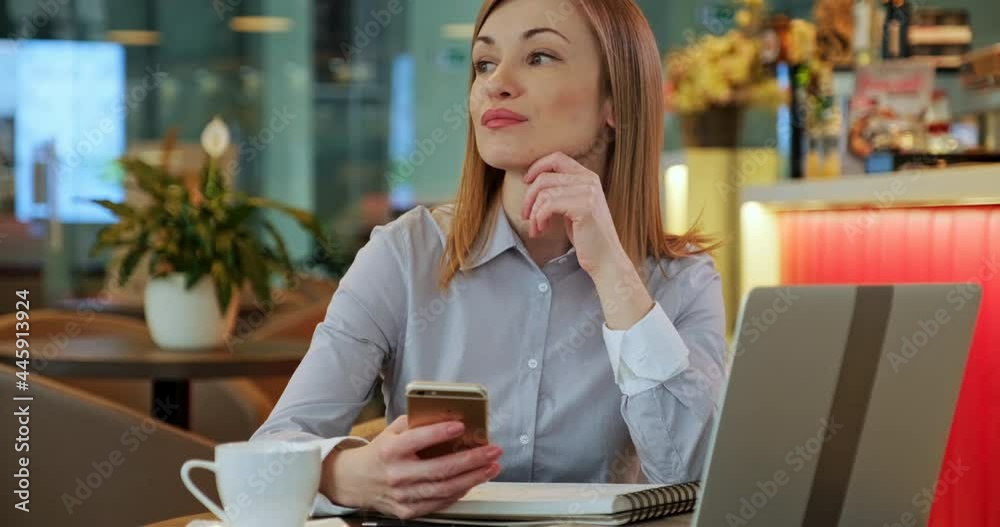 Business woman using cell phone, she has laptop pc, in the restaurant. Dolly shot Business woman using cell phone, she has laptop pc, in the restaurant. Dolly shot