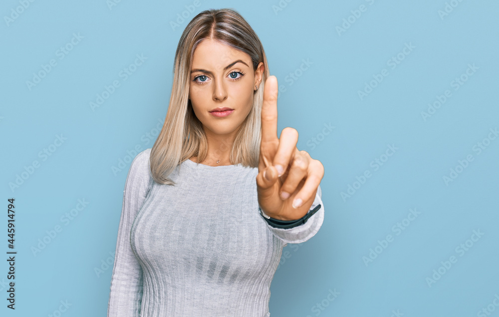 Beautiful blonde woman wearing casual clothes pointing with finger up and angry expression, showing no gesture Beautiful blonde woman wearing casual clothes pointing with finger up and angry expression, showing no gesture