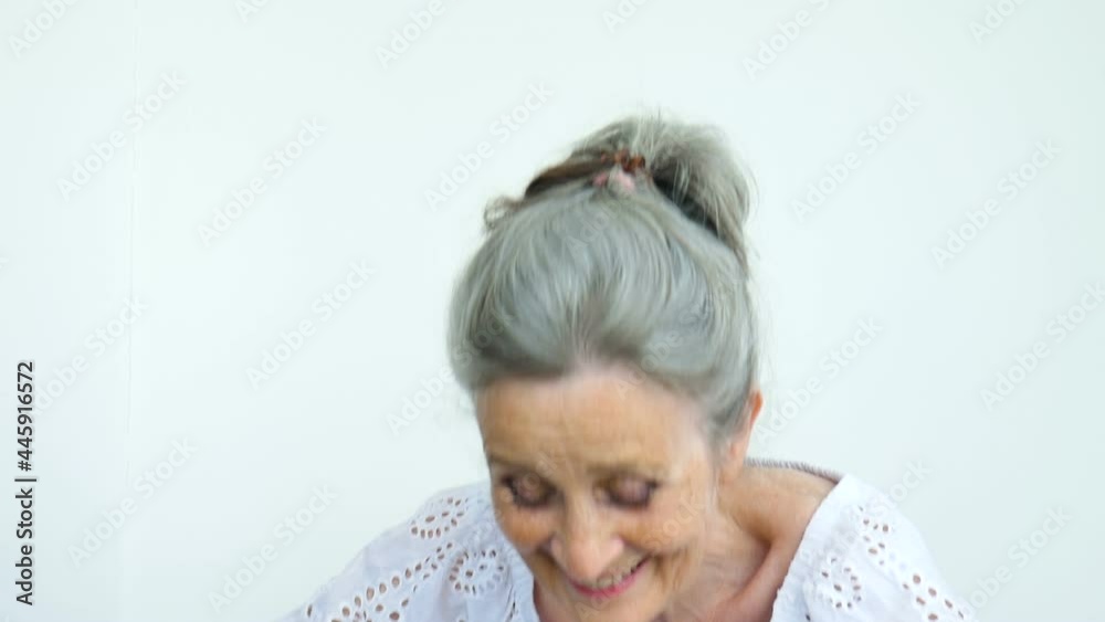 Beautiful old grandmother with grey hair and face with wrinkles is looking at the camera with smile on white background, mothers day, happy retirement Beautiful old grandmother with grey hair and face with wrinkles is looking at the camera with smile on white background, mothers day, happy retirement
