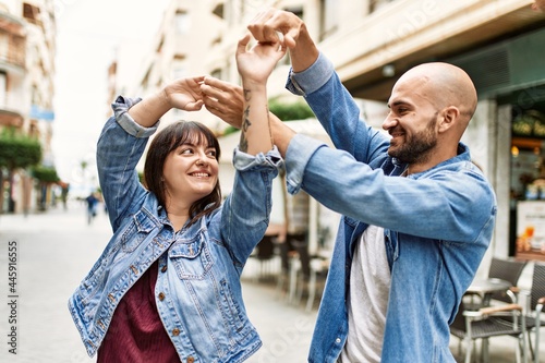 Canvas Print Young hispanic couple smiling happy dancing at the city.