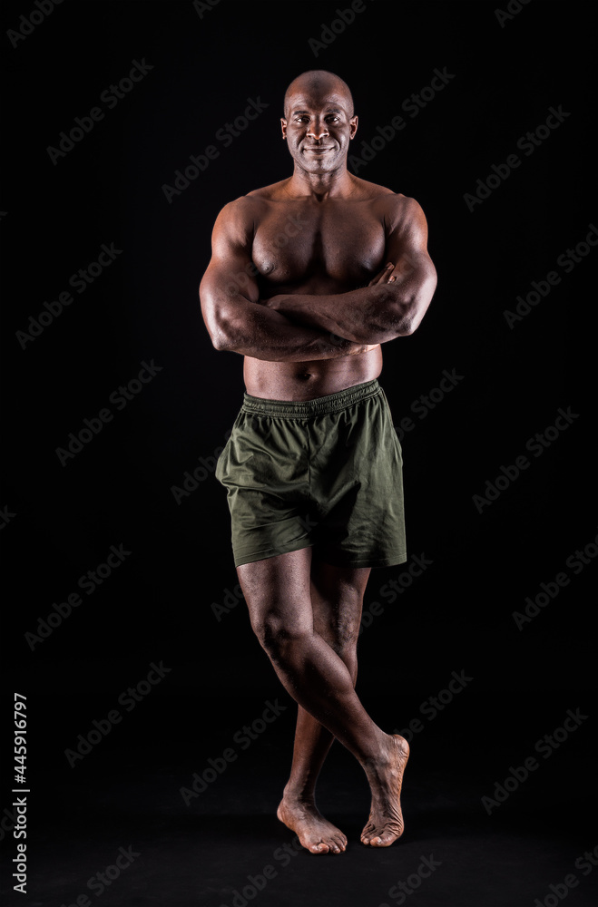 African American man standing looking at camera with arms crossed. 
