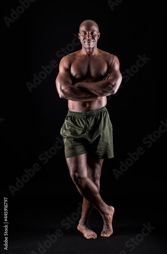 African American man standing looking at camera with arms crossed. 