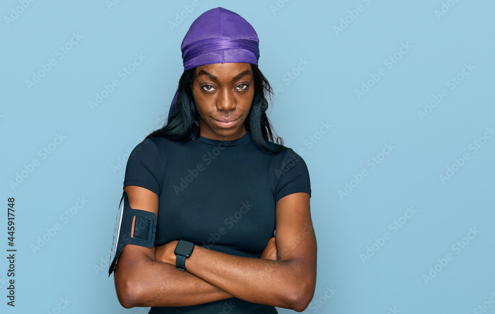 Young african american woman wearing sportswear skeptic and nervous, disapproving expression on face with crossed arms. negative person.