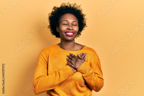 Young african american woman wearing casual clothes smiling with hands on chest with closed eyes and grateful gesture on face. health concept. © Krakenimages.com