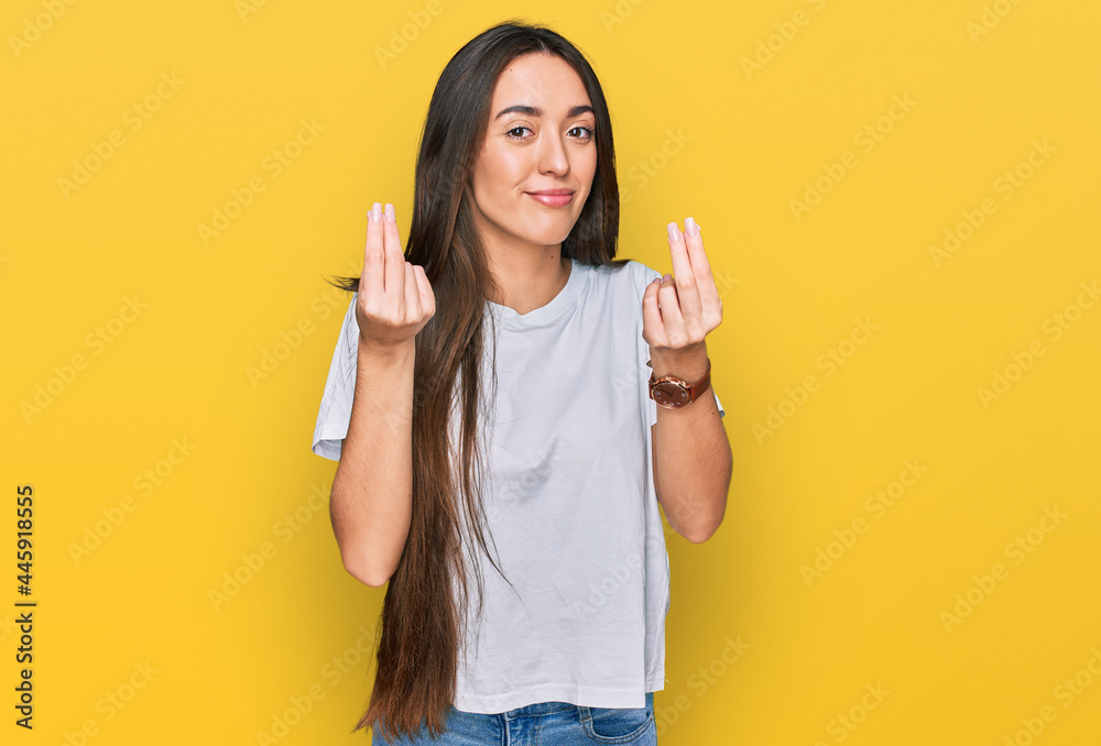 Young hispanic girl wearing casual white t shirt doing money gesture with hands, asking for salary payment, millionaire business Young hispanic girl wearing casual white t shirt doing money gesture with hands, asking for salary payment, millionaire business