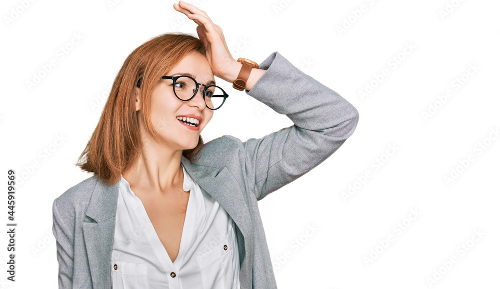 Young caucasian woman wearing business style and glasses smiling confident touching hair with hand up gesture, posing attractive and fashionable Young caucasian woman wearing business style and glasses smiling confident touching hair with hand up gesture, posing attractive and fashionable