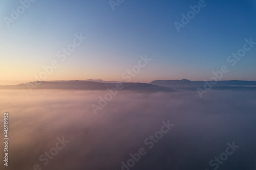 Landscape shot above the fog. Hill panorama of swabian alb on the horizon. Blue sky for copy space. Aerial view.
