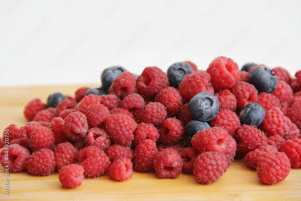blueberries and raspberries on a white background. Useful vitamins berries in summer blueberries and raspberries on a white background. Useful vitamins berries in summer