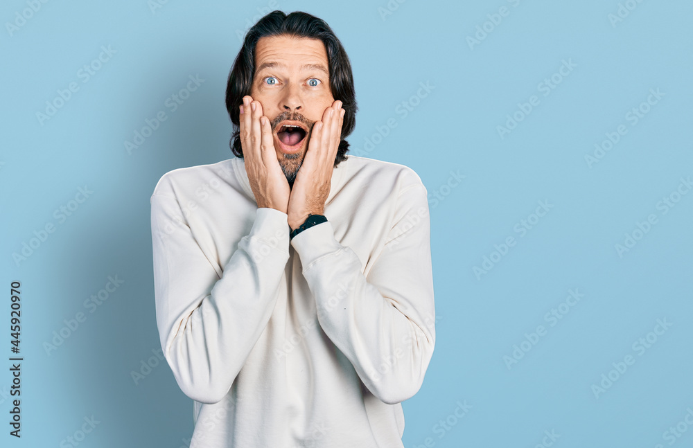 Middle age caucasian man wearing casual clothes afraid and shocked, surprise and amazed expression with hands on face Middle age caucasian man wearing casual clothes afraid and shocked, surprise and amazed expression with hands on face