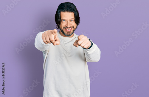 Middle age caucasian man wearing casual clothes pointing to you and the camera with fingers, smiling positive and cheerful © Krakenimages.com