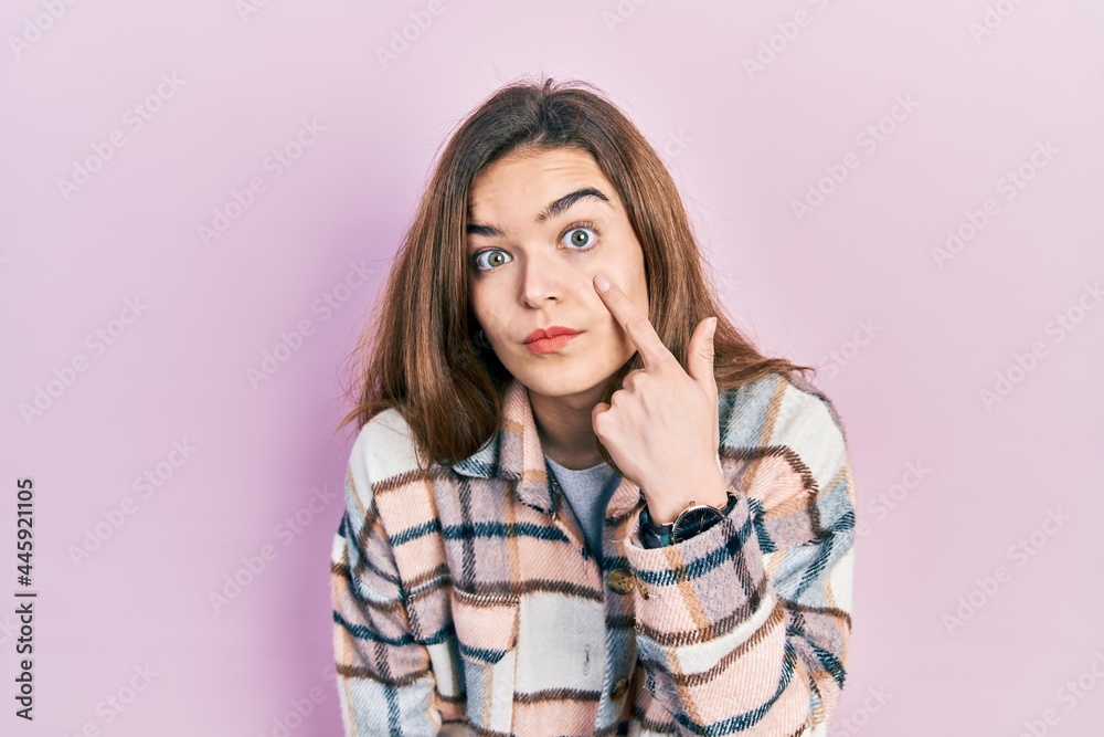 Fototapeta premium Young caucasian girl wearing casual clothes pointing to the eye watching you gesture, suspicious expression