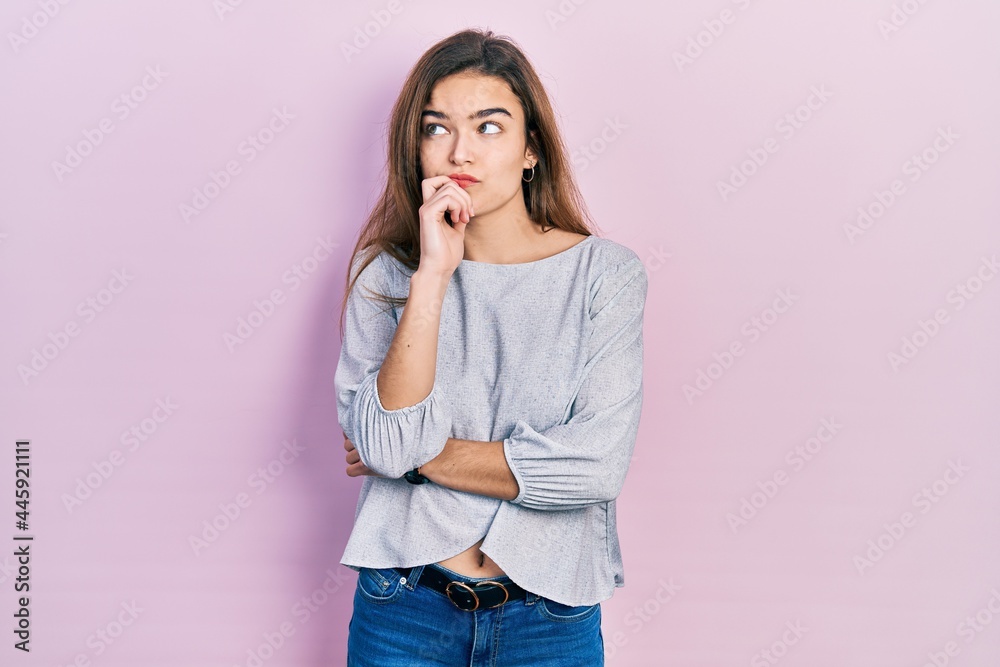 Young caucasian girl wearing casual clothes serious face thinking about question with hand on chin, thoughtful about confusing idea Young caucasian girl wearing casual clothes serious face thinking about question with hand on chin, thoughtful about confusing idea