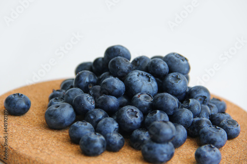 blueberry berries on a wooden and white background