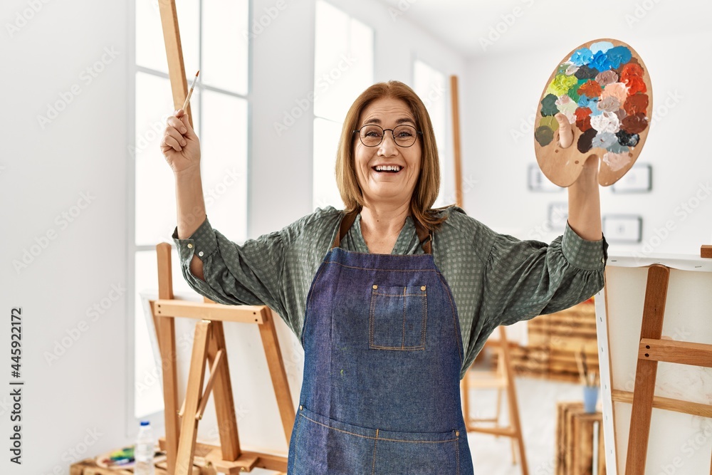 Middle age artist woman smiling happy painting at art studio Middle age artist woman smiling happy painting at art studio