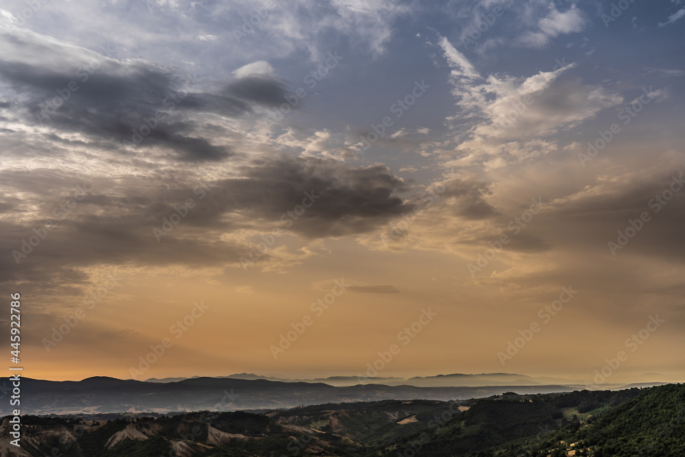 Beautiful landscape in Italy at sunrise with a beautiful sky with clouds and fantastic colors with the hills in the background.