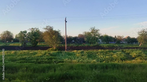 View from the window of high speed train with beautiful panoramic landscape of nature, green trees, bushes in springtime photo